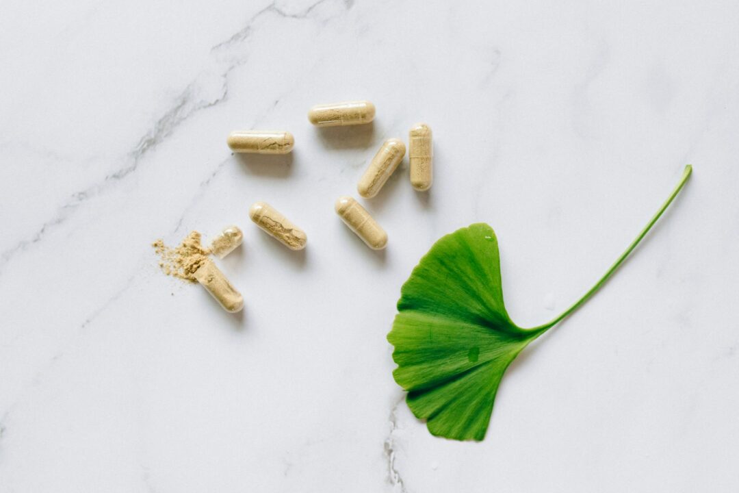 home 14 Top view of Ginkgo Biloba capsules with a leaf on a marble surface, symbolizing natural supplements.